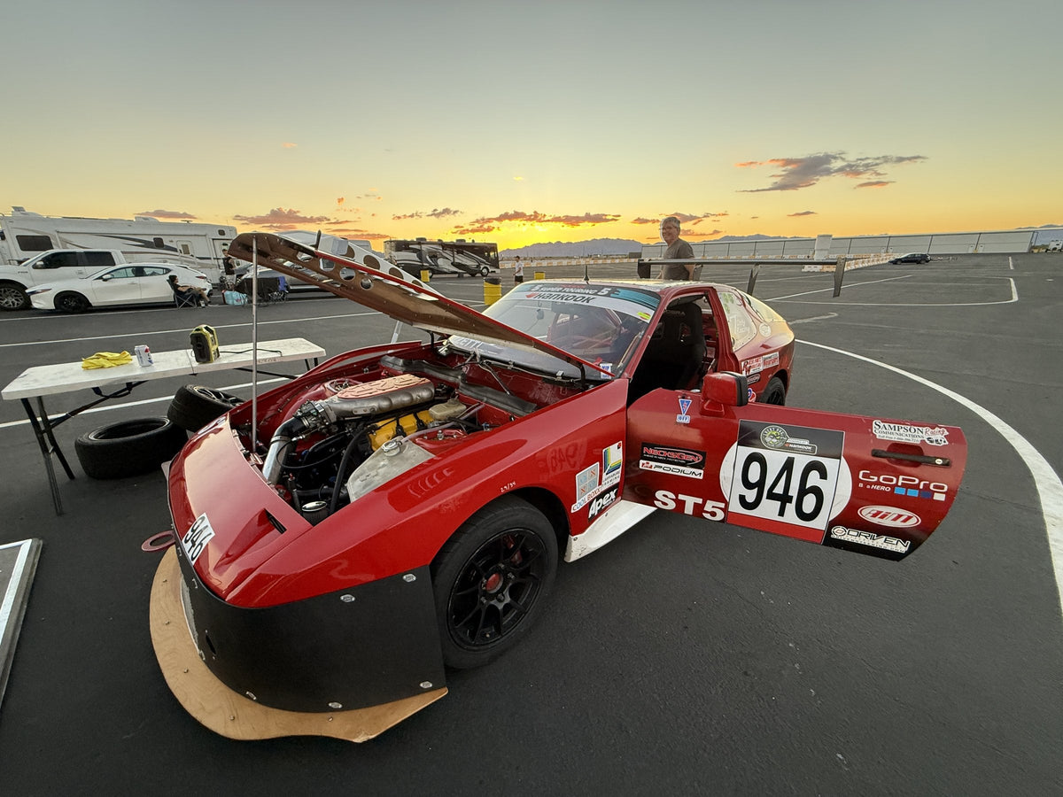 Slowdog Racing's red number 946 endurance race car at sunset in the Chuckwalla Valley Raceway paddock during the Lucky Dog Racing League Wild Dawgs weekend